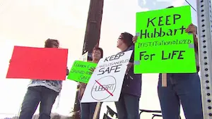 Demonstrators holding signs against sex offender Chris Hubbard