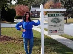 Beth Hunter standing next to For Lease sign