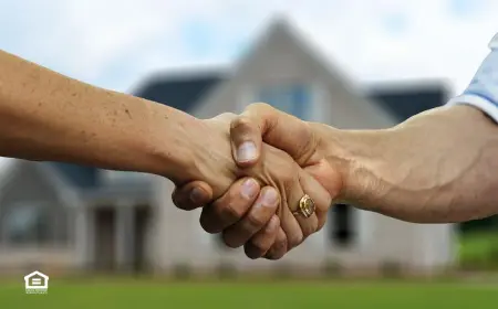 Landlord and tenant shaking hands in front of house