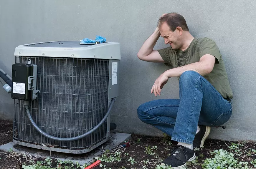 Man frustrated with fixing air conditioner