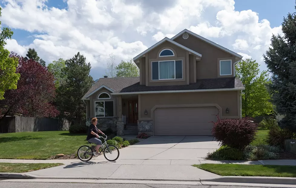 bike rider goes by a home