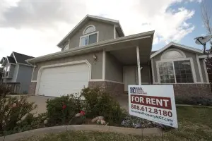 Gray house with "For Rent" sign