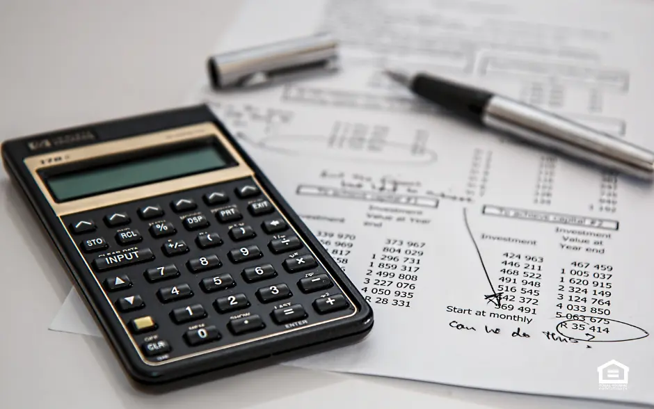 Calculator and pen on top of business documents