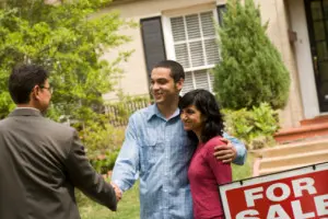 Couple standing outside a house for sale with property manager