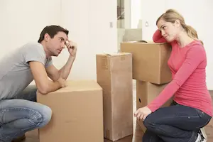 Mand and woman sitting around packed boxes