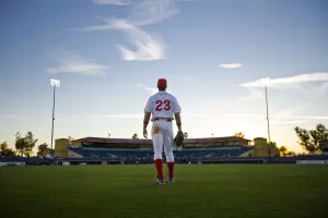 Man standing in the outfield of a baseball diamond