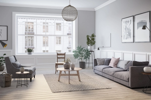Brightly lit living room interior with large window and modern furniture in neutral colors.