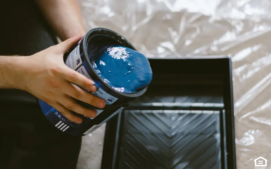 blue paint being poured out of a can