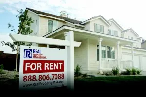 White two-story house with for rent sign