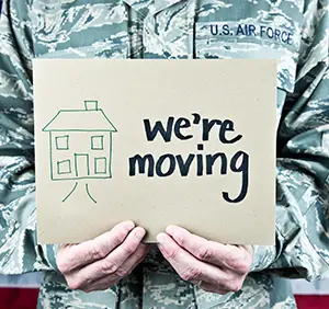 Solider holding a "we're moving" sign