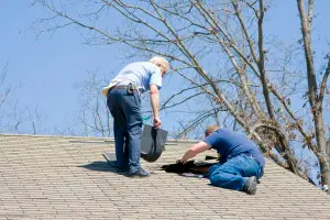 Two men fixing roof