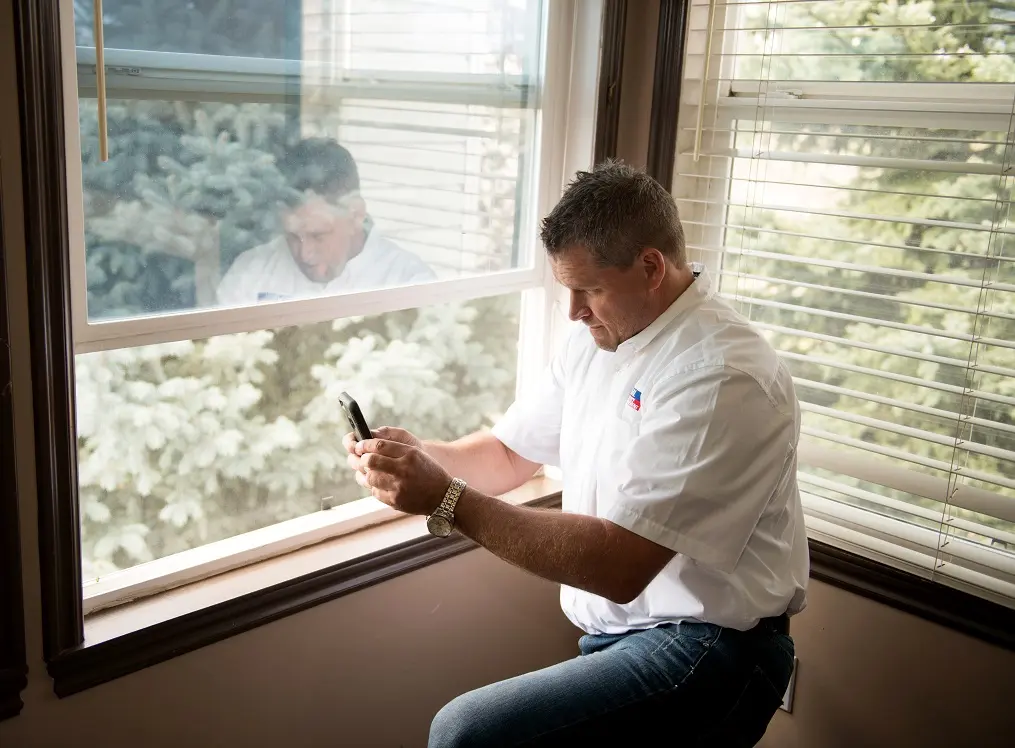 man checking windows in a home
