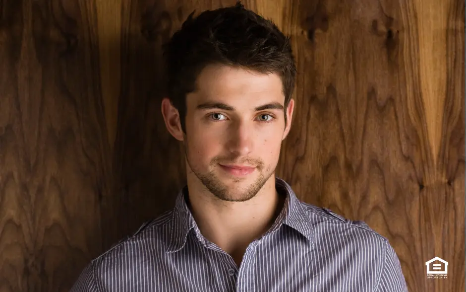 Man standing in front of wood panel at a rental property